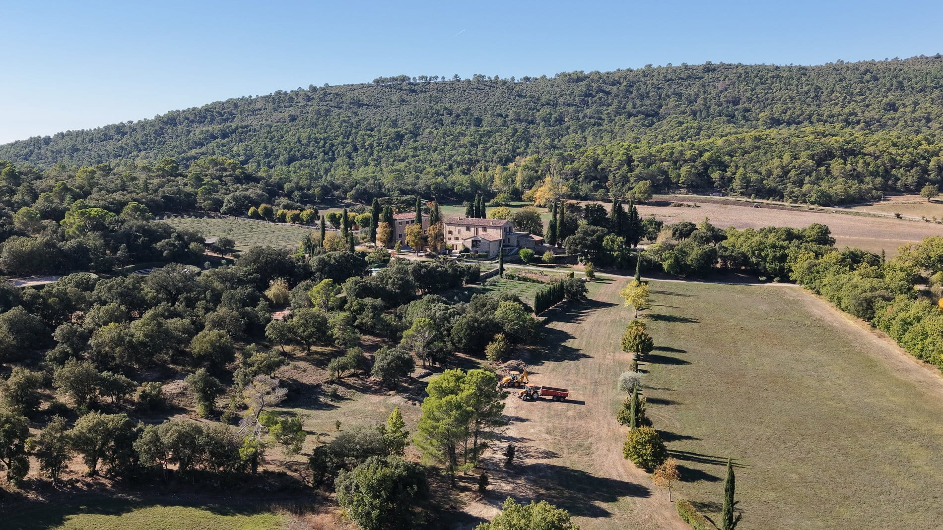 A landed estate with open meadows, natural water sources, and pathways winding through the property.